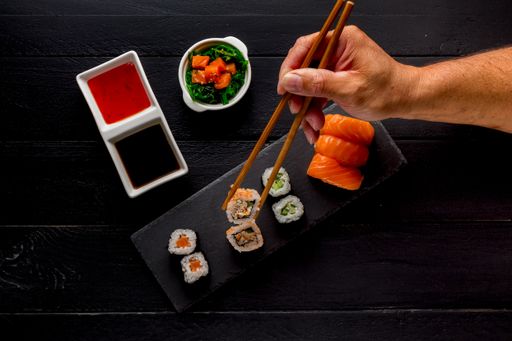 A top view of sushi and roll assortment on dark wooden background