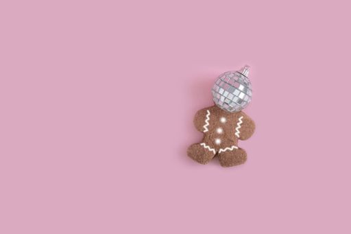 A top view of a cute bear cookie with a reflective ball on a pink background
