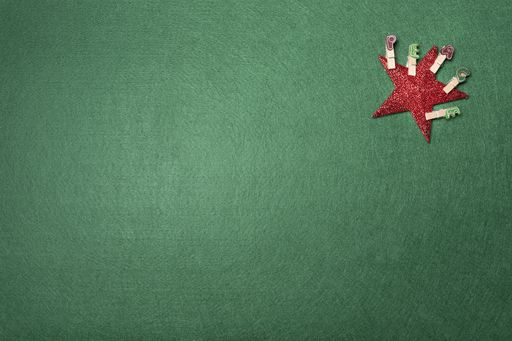 A top view of a red star with peace word clips on a green background