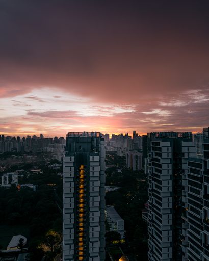 A vertical shot of the cityscape of tall buildings captured during a sunset