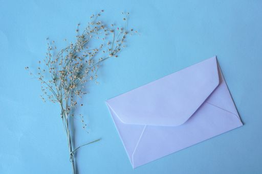 A white envelope with dried grass for greeting mockup seasonal concepts on blue background