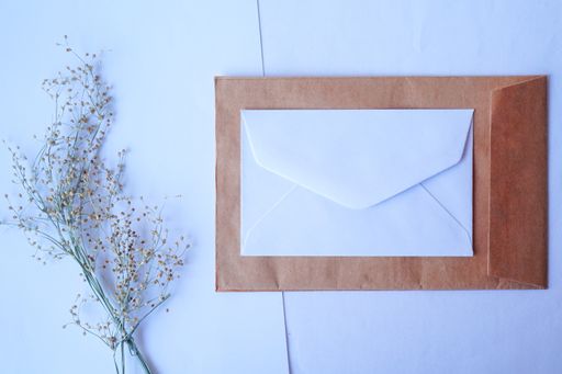 A top view of a brown envelope and blank white letter with dried grass for mockup greeting seasonal concepts
