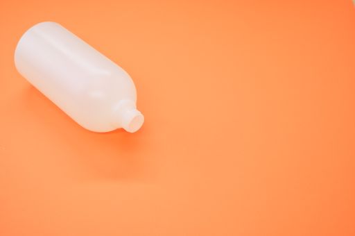 A closeup shot of a plastic bottle on an orange background