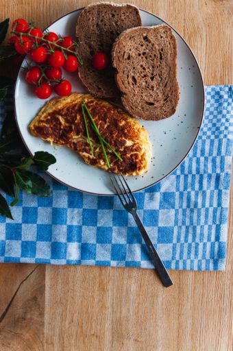 A top view of omelet, cherry tomatoes and bread - a perfect breakfast