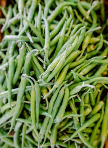 A closeup shot of fresh green chilies displayed in a marketplace