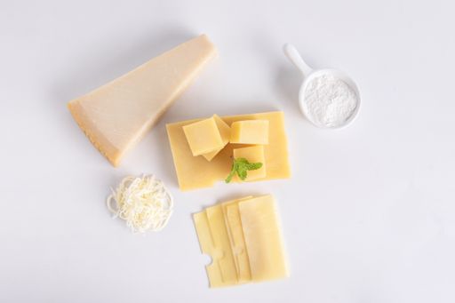 A top view of Swiss cheese and a piece of parmesan cheese isolated on a gray background