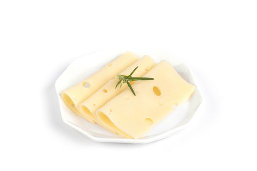 A closeup of Swiss cheese slices with rosemary on a plate isolated on a white background