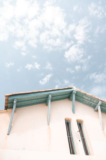 View of a small building with a beautiful roof in front of a blue sky at the beach in Bormes-Les-Mimosas, France.