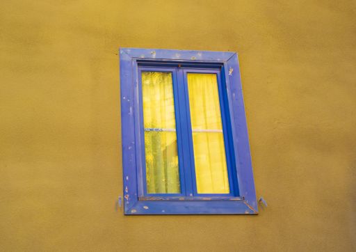 A window on a yellow concrete wall