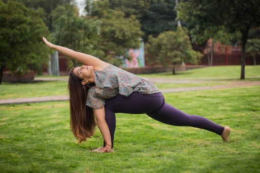 A closeup of a young female practicing yoga in a park on a sunny summer day