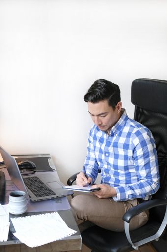 A vertical shot of a young businessman working from home