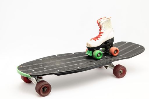A closeup shot of a white roller skate on a black skateboard