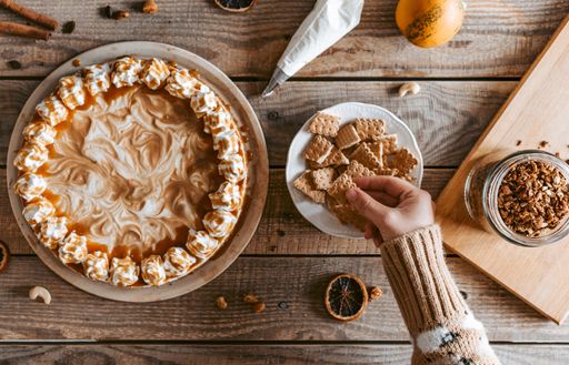 The flat lay of a served yummy pumpkin cheesecake and its ingredients