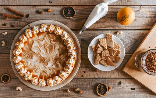 The flat lay of a served yummy pumpkin cheesecake and its ingredients