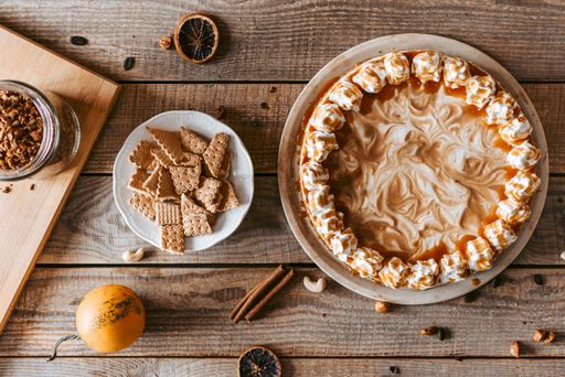 The flat lay of a served yummy pumpkin cheesecake and its ingredients