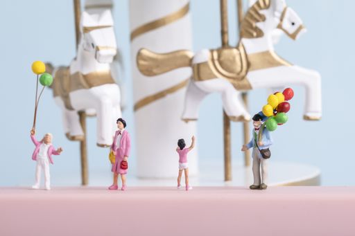 A closeup shot of small cute human figurines playing with balloons