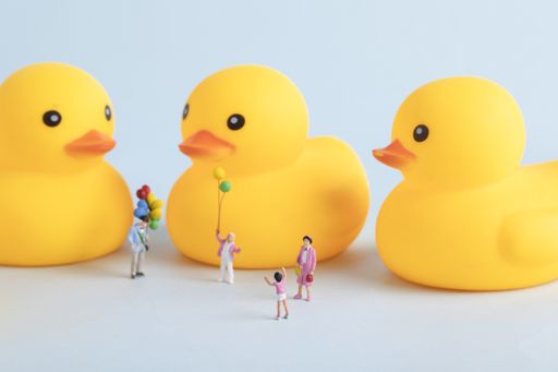 A closeup shot of yellow duck toys and people figures - children's day concept