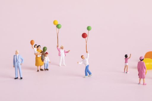 A closeup shot of small cute human figurines playing with balloons