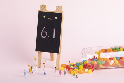 A closeup shot of human figurines, jelly beans, and a calendar sign
