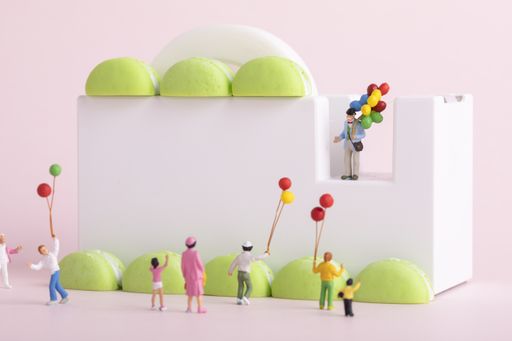 A closeup shot of people figures with balloon in a macaron park