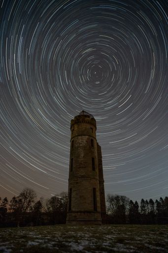Spiral stars over old tower on the ruins of Eglinton Castle Irvine in Scotland. Long exposure