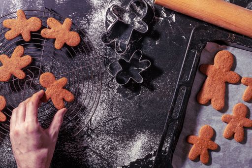a top view of a hand touching the gingerbread man cookie