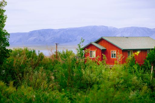 A scenic view of red wooden house on the shore of Mammoth lake against mountain, CA, USA