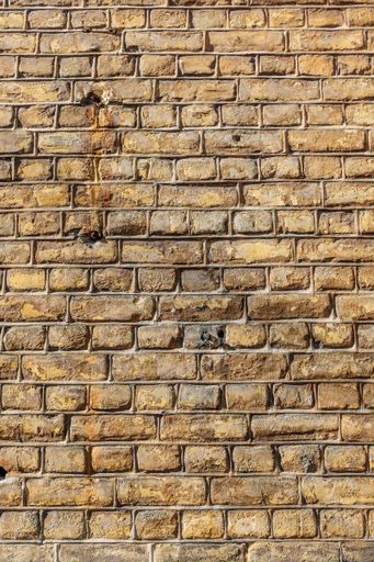 A vertical shot of a weathered brick wall - great for background or wallpaper