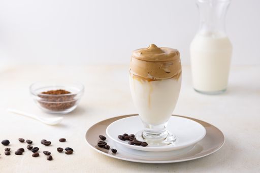 A soft focus of dalgona coffee topped with chocolate chips and a cinnamon stick