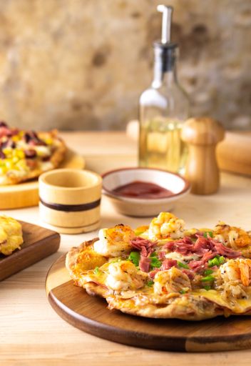 A vertical shot of different delicious pizzas on wooden boards on the table