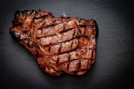 ethically raised, fresh cut organic rib eye steak grilled rare
