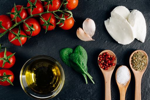 A top view closeup of the fresh cherry tomatoes, mozzarella, spice tablespoon, garlic, and spinach
