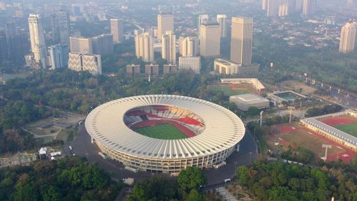 An aerial shot of the beautiful modern city with buildings, greenery, and a sport stadium