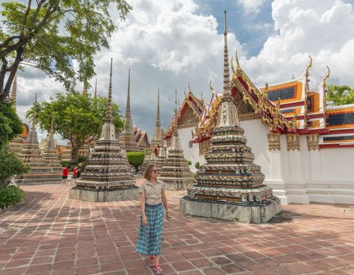 A caucasian female tourist visiting the Wat Pho Buddhist Temple in Bangkok, Thailand