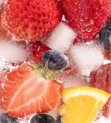 A vertical closeup shot of berries in sparkling water