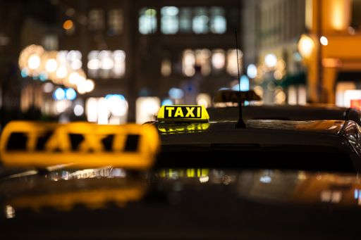 The yellow TAXI signs on the taxis captured at night