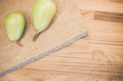 A top view of green pears on a natural wooden surface