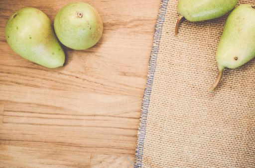 A top view of green pears on a natural wooden surface