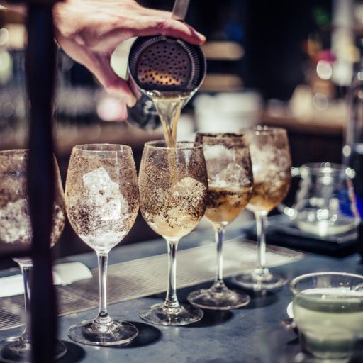 The bartender making an alcoholic cocktail, a summer cocktail in the bar