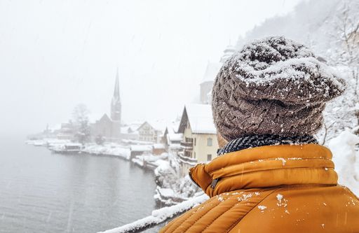 A back view of a young woman looking in Hallstatt village in Austria during winter
