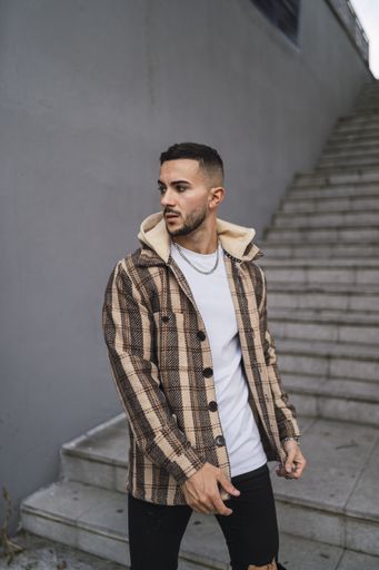 A vertical shot of an attractive male coming down the stairs