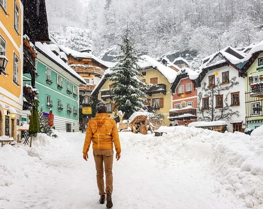 A back view of a young male walking on a mountain resort town in Austria during winter