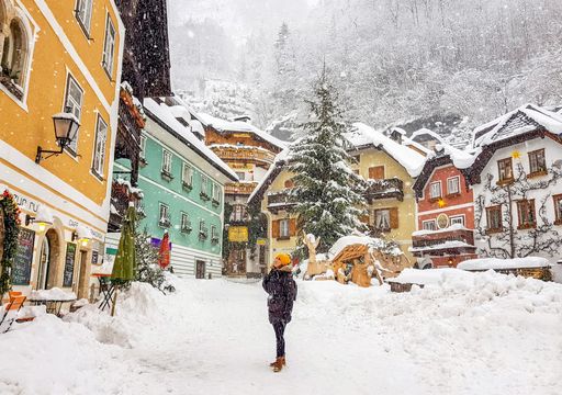 A view of a young woman walking on a mountain resort town in Austria during winter