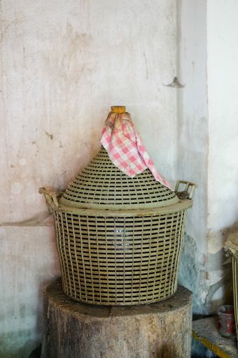 A selective focus shot of large dusty wine containers in a storage room