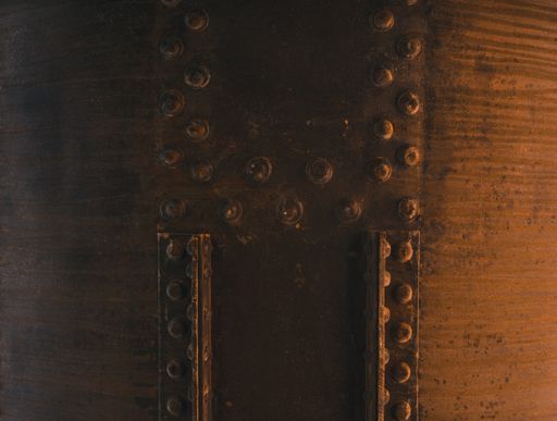 A close up shot of a big rusty tank with bolt fixed with metal pieces