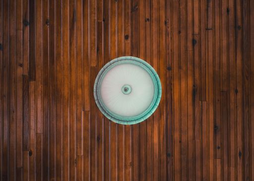 A white and blue chandelier hanging on the wooden ceiling showing from below