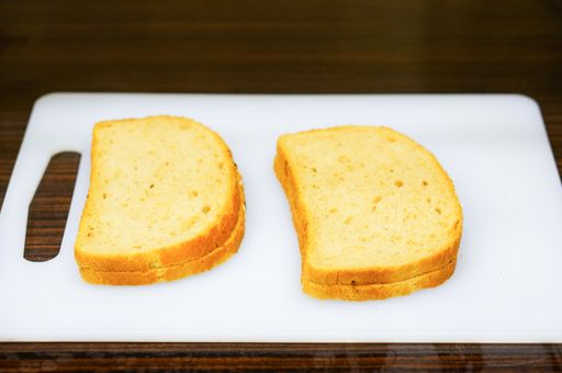 A shot of four slices of bread on a white cutting board