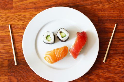 A top view of Sushi and rolls served with two sticks
