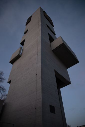 A low angle shot of a modern interesting building in the evening on the blue sky background