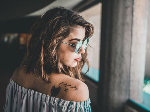 A young beautiful girl with sunglasses looking over her shoulder at a museum in Chihuahua, Mexico